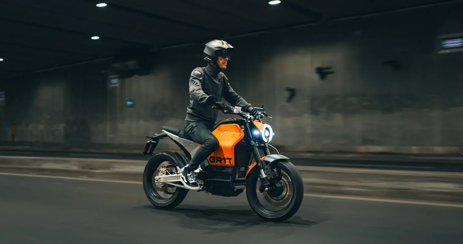 Grit electric motorcycle riding through an urban tunnel