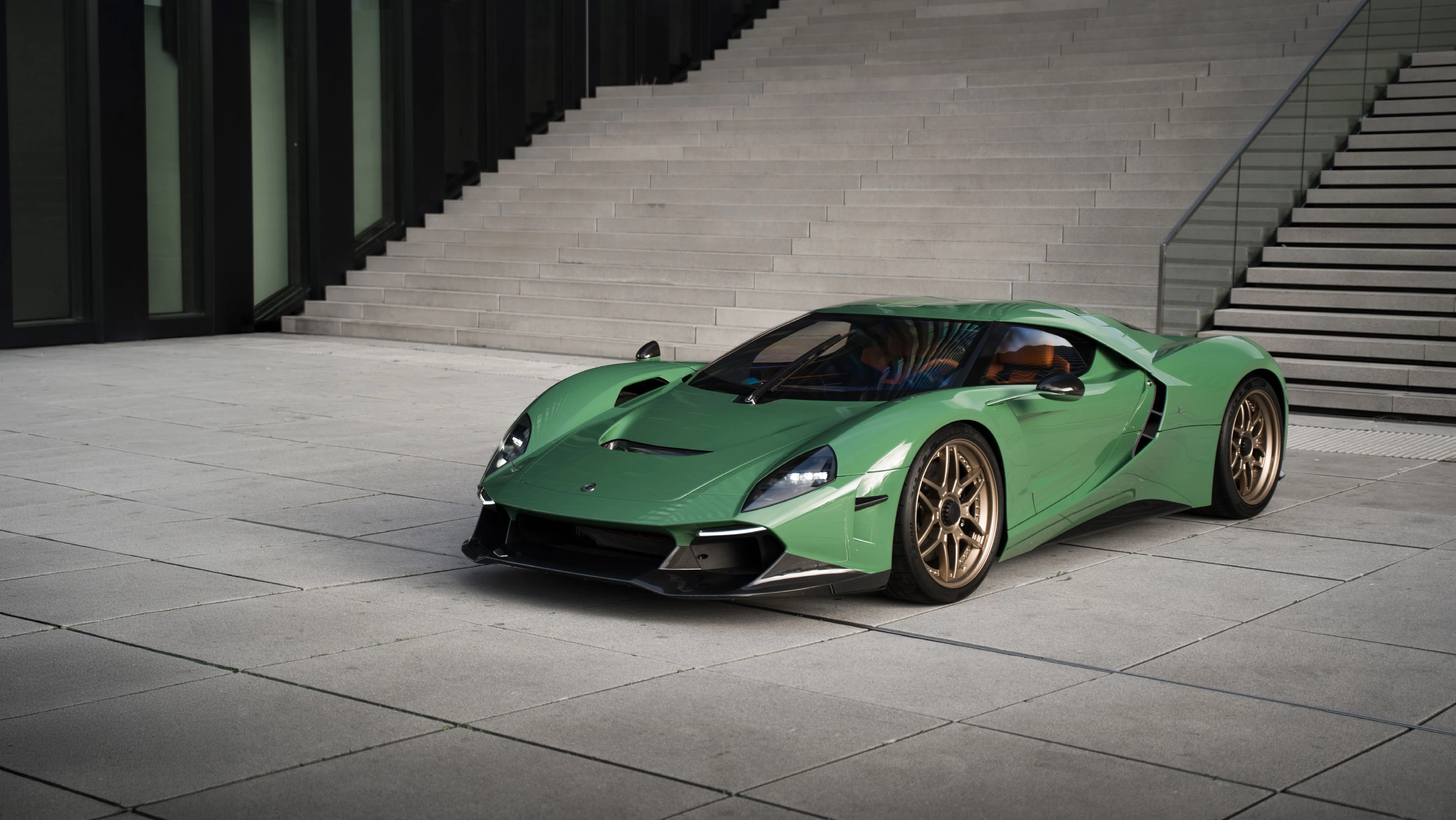 The complete green Capricorn Zagato beneath an architectural concrete staircase