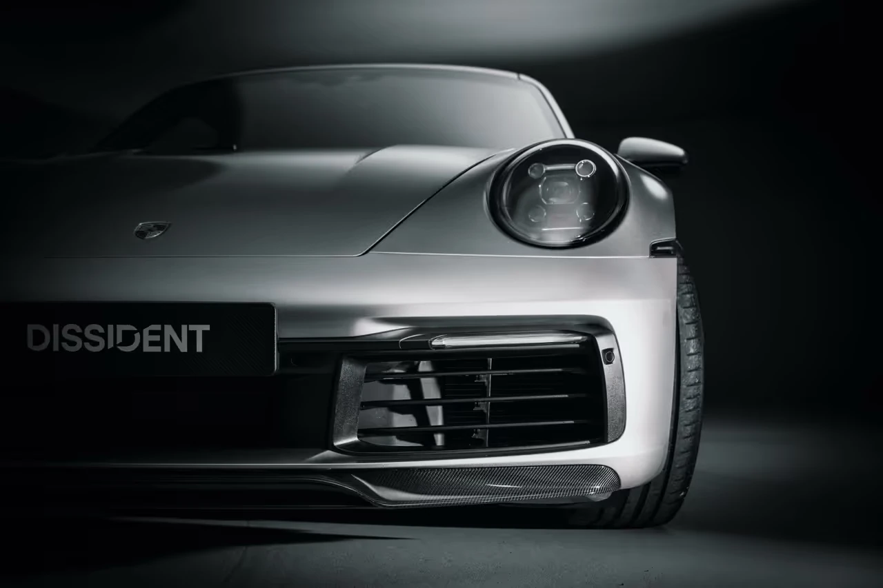 Close view of the silver Porsche front bumper and Dissident carbon treatment