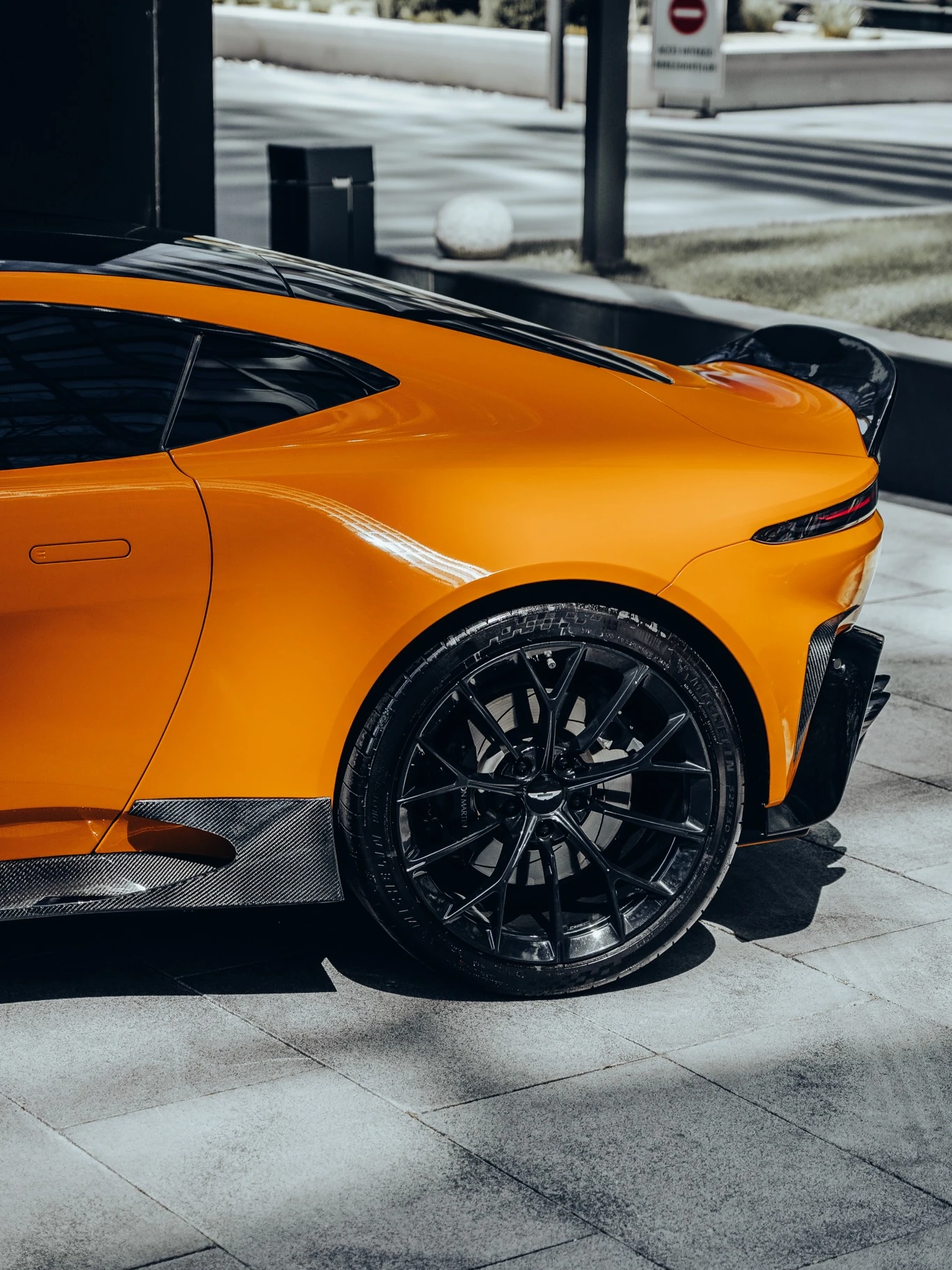 Rear quarter, wheel and carbon detailing of the orange OLIGARCH Vantage